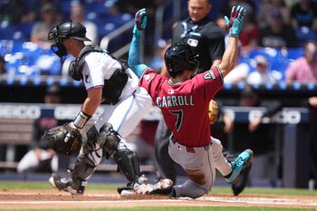 Apr 17, 2025; Miami, Florida, USA;  Arizona Diamondbacks right fielder Corbin Carroll (7) scores a run as Miami Marlins catcher Rob Brantly (19) looks on at loanDepot Park. Mandatory Credit: Jim Rassol-Imagn Images