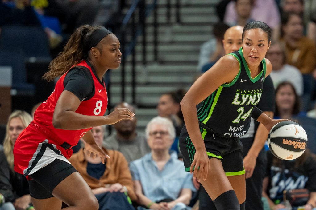 Jun 17, 2025; Minneapolis, Minnesota, USA; Minnesota Lynx forward Napheesa Collier (24) backs towards the basket as Las Vegas Aces forward Joyner Holmes (8) plays defense in the first half at Target Center. Mandatory Credit: Jesse Johnson-Imagn Images
