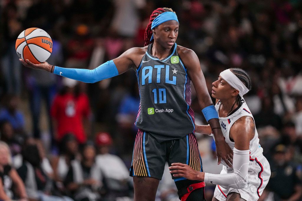 Jun 20, 2025; College Park, Georgia, USA; Atlanta Dream guard Rhyne Howard (10) protects the ball from Washington Mystics guard Brittney Sykes (20) during the first half at Gateway Center Arena at College Park. Mandatory Credit: Dale Zanine-Imagn Images