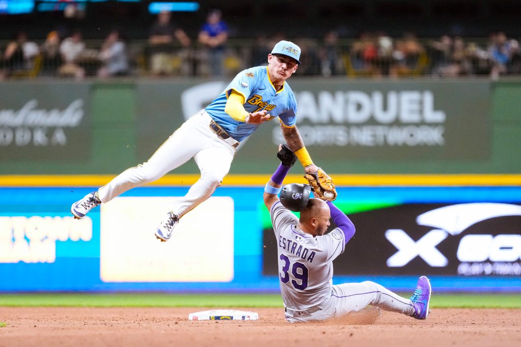 Jun 27, 2025; Milwaukee, Wisconsin, USA;  Colorado Rockies second baseman Thairo Estrada (39) is tagged out but Milwaukee Brewers shortstop Joey Ortiz (3) while trying to steal second base during the seventh inning at American Family Field. Mandatory Credit: Jeff Hanisch-Imagn Images
