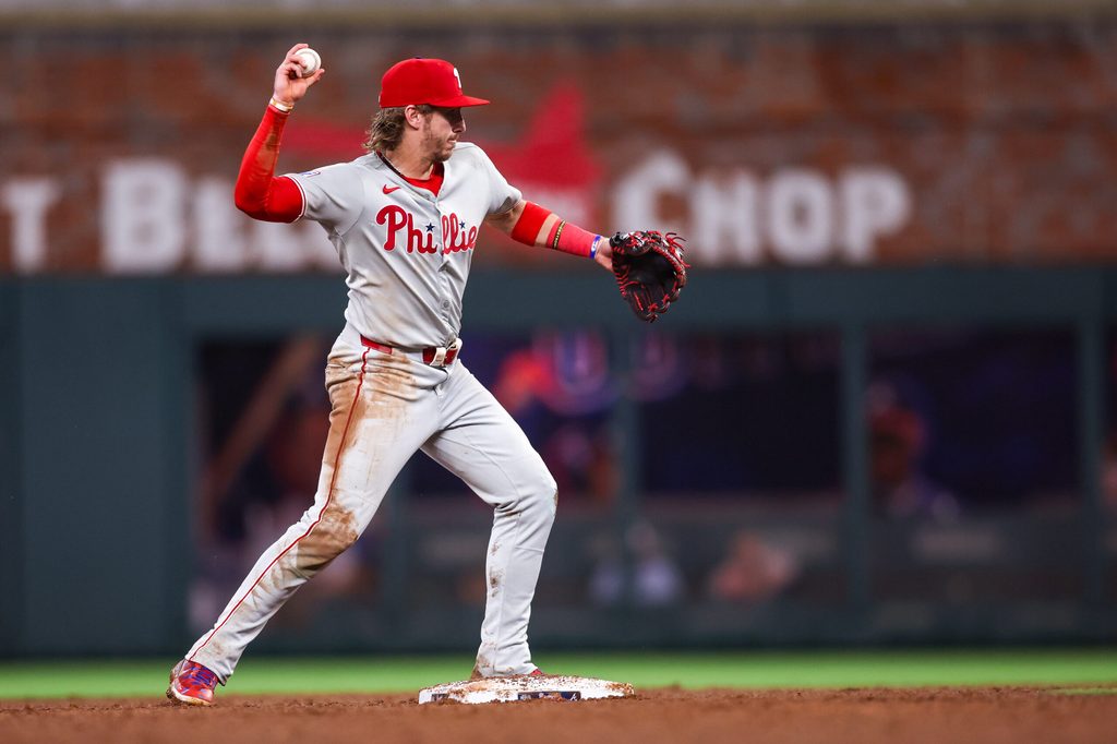Jun 27, 2025; Atlanta, Georgia, USA; Philadelphia Phillies second baseman Bryson Stott (5) turns a double play against the Atlanta Braves in the fifth inning at Truist Park. Mandatory Credit: Brett Davis-Imagn Images