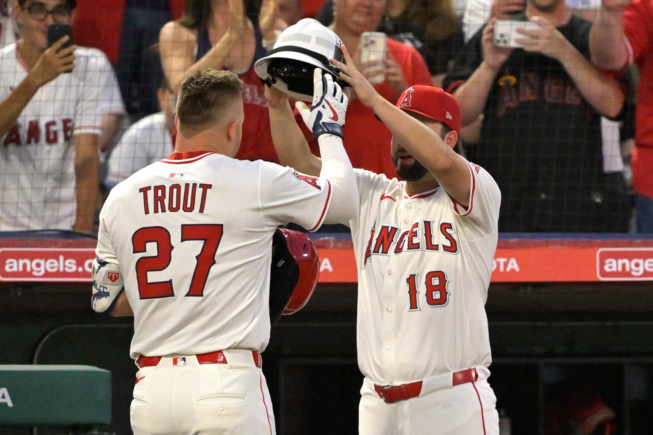 Jun 28, 2025; Anaheim, California, USA;  Los Angeles Angels right fielder Mike Trout (27) is is greeted at the dugout by first baseman Nolan Schanuel (18) after hitting a solo home run in the seventh inning against the Washington Nationals at Angel Stadium. Mandatory Credit: Jayne Kamin-Oncea-Imagn Images