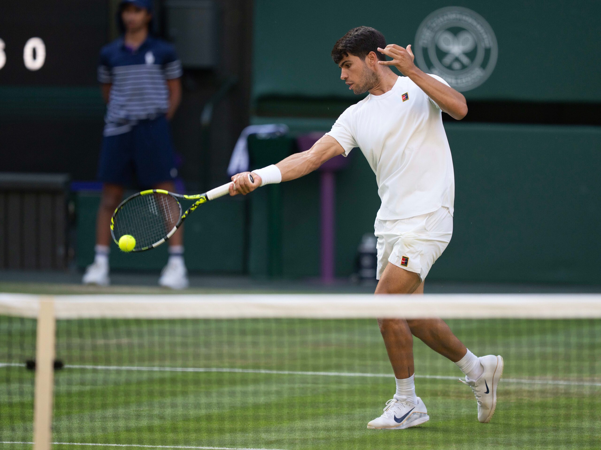 Jul 4, 2025; Wimbledon, United Kingdom;  Carlos Alcaraz of Spain returns a shot during his match against Jan-Lennard Struff of Germany on day five at the All England Lawn Tennis and Croquet Club. Mandatory Credit: Susan Mullane-Imagn Images