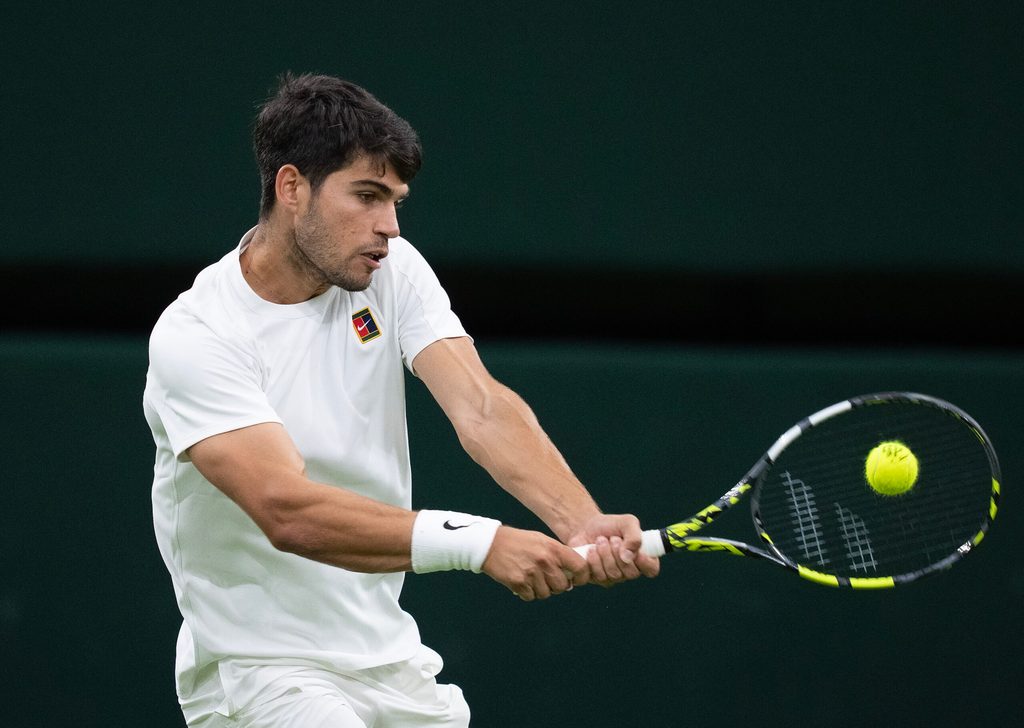 Jul 6, 2025; Wimbledon, United Kingdom; Carlos Alcaraz of Spain returns a shot during his match against Andrey Rublev on day seven at the All England Lawn Tennis and Croquet Club. Mandatory Credit: Susan Mullane-Imagn Images