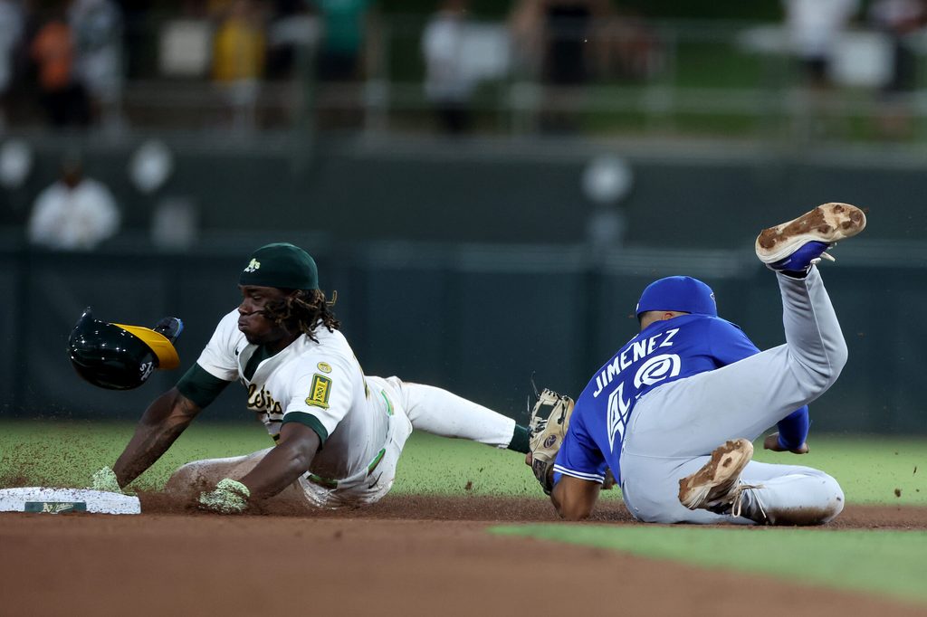 Jul 12, 2025; West Sacramento, California, USA; Athletics right fielder Lawrence Butler (4) is tagged out by Toronto Blue Jays second baseman Leo Jimenez (49) on a steal attempt during the fifth inning  at Sutter Health Park. Mandatory Credit: Dennis Lee-Imagn Images