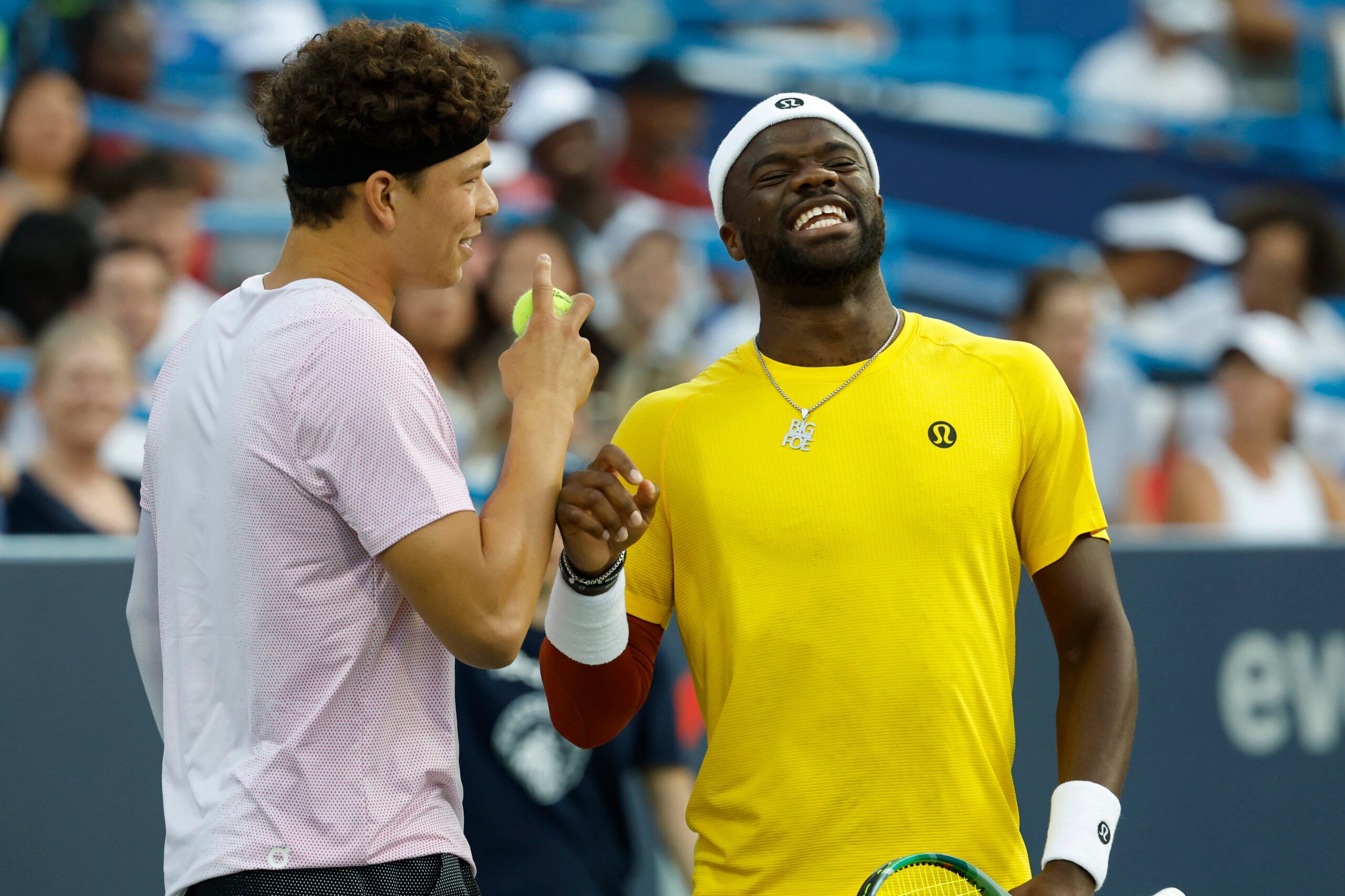 Jul 21, 2025; Washington, D.C., USA; Ben Shelton (USA)(L), jokes with partner Frances Tiafoe (USA)(R) between points against Matthew Ebden and John Peers (both of AUS)(both not pictured) in a men's doubles match on day one of the Mubadala Citi DC Open at Rock Creek Park Tennis Center. Mandatory Credit: Geoff Burke-Imagn Images