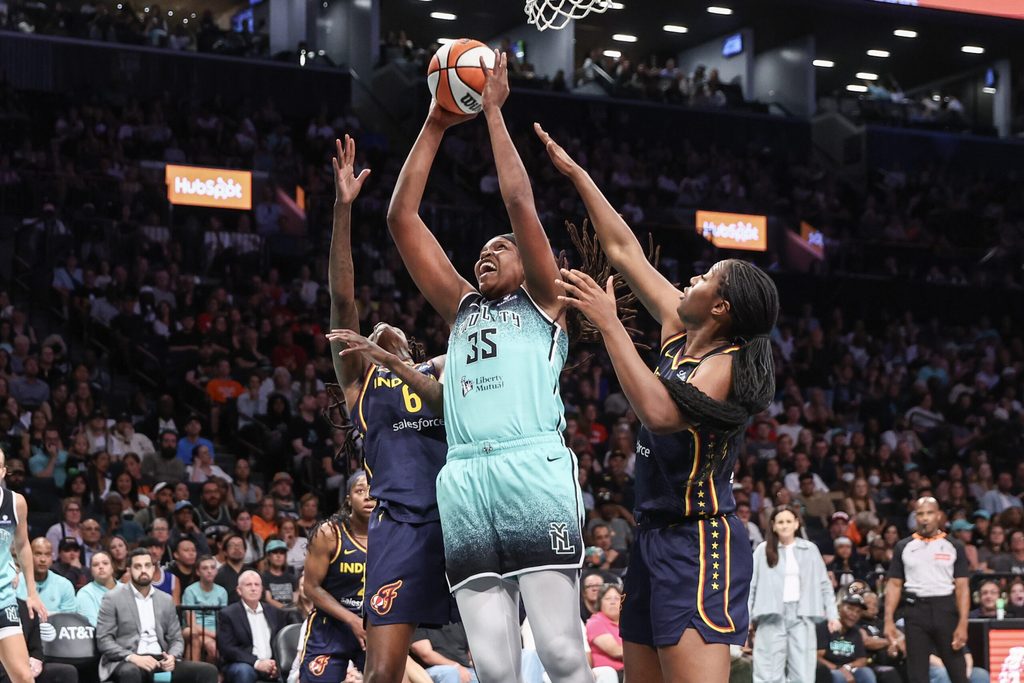 Jul 22, 2025; Brooklyn, New York, USA; New York Liberty center Jonquel Jones (35) jumps in front of Indiana Fever forwards Natasha Howard (6) and Aliyah Boston (7) to grab a rebound in the first quarter at Barclays Center. Mandatory Credit: Wendell Cruz-Imagn Images