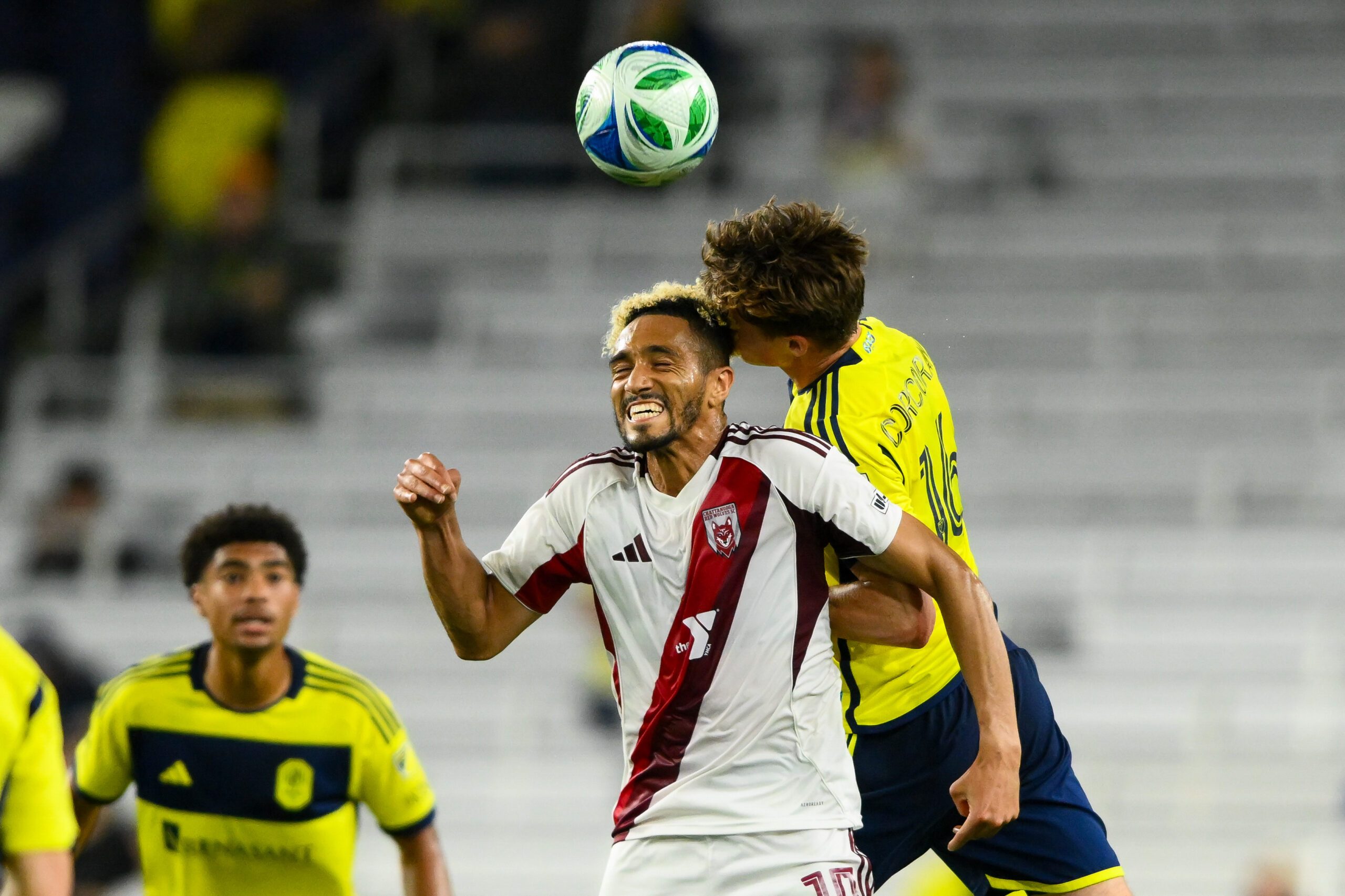May 6, 2025; Nashville, Tennessee, USA;  Nashville SC midfielder Matthew Corcoran (16) and Chattanooga Red Wolves center fielder Matt Bentley (10) fights for the ball during the second half at GEODIS Park. Mandatory Credit: Steve Roberts-Imagn Images