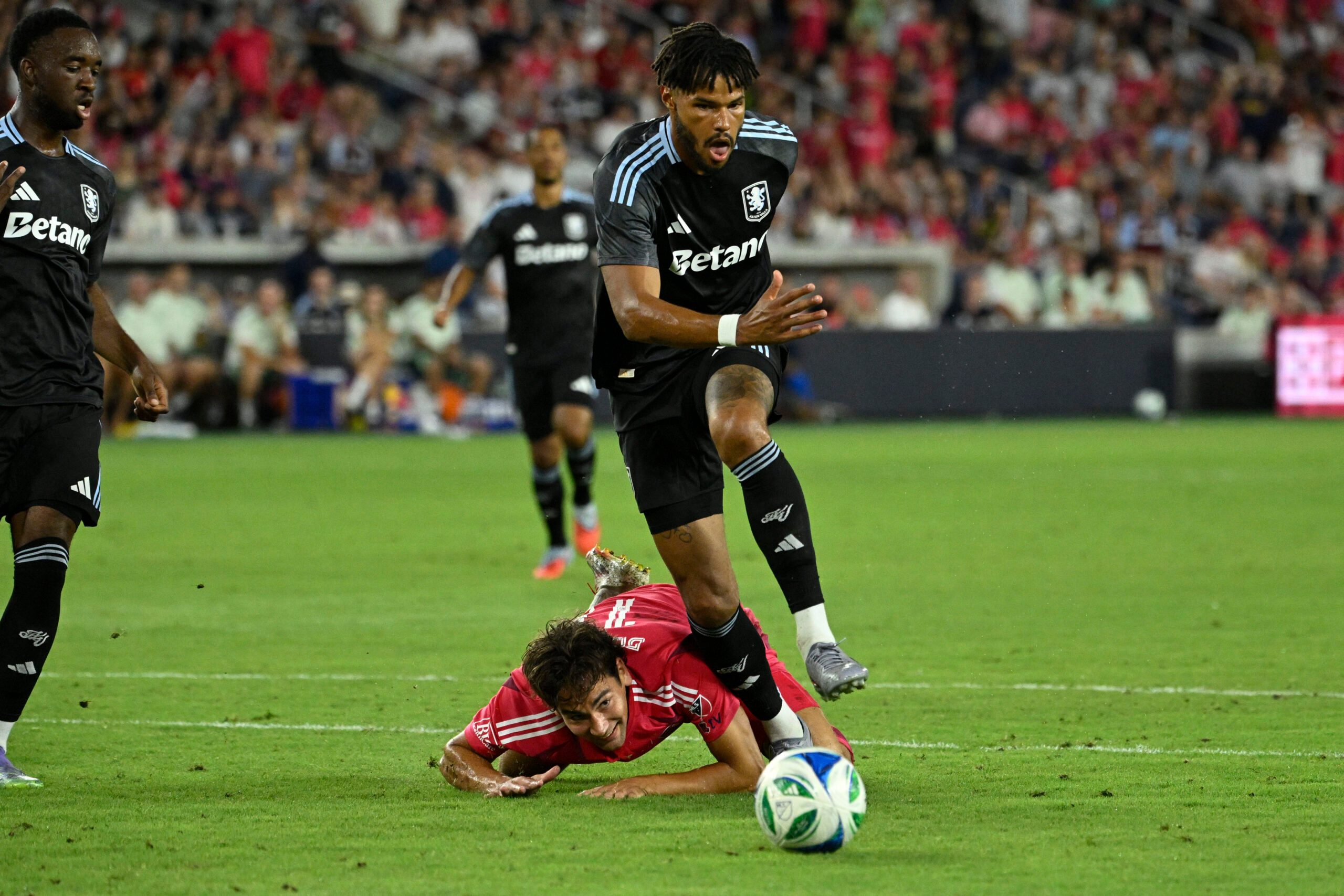 Jul 30, 2025; St. Louis, Missouri, USA; St. Louis City forward Simon Becher (11) falls to the pitch while battling Aston Villa defender Tyrone Mings (5) for the ball in the second half at Energizer Park. Mandatory Credit: Joe Puetz-Imagn Images