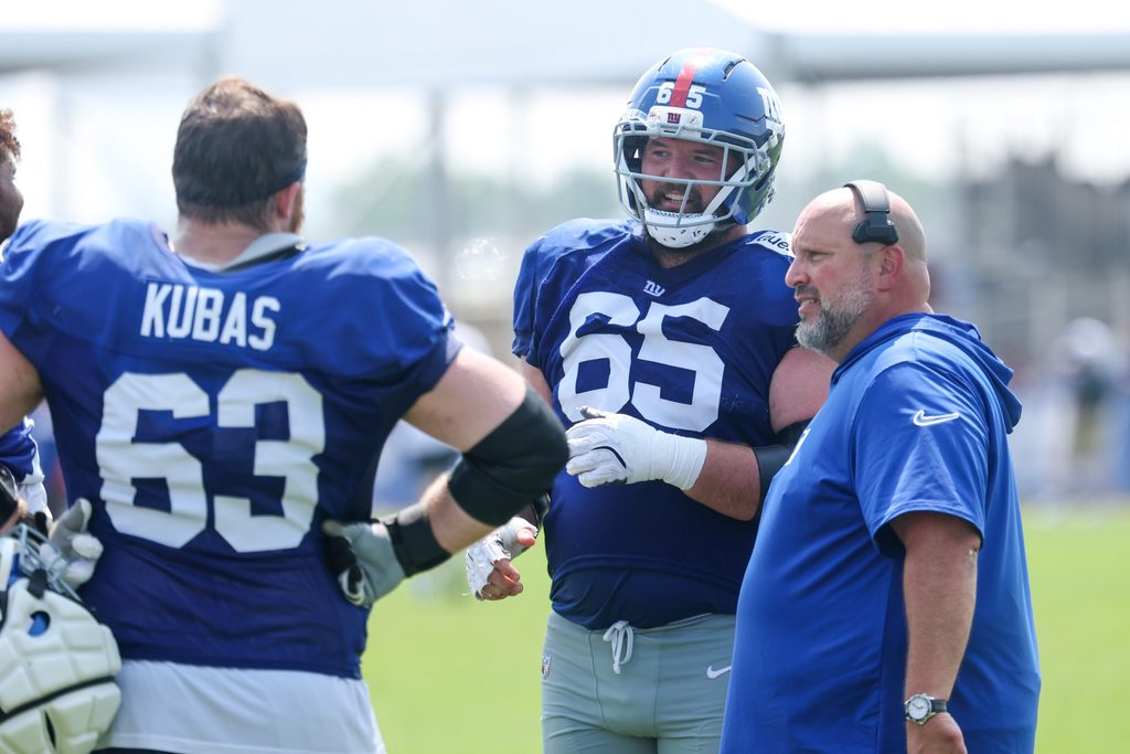 Aug 4, 2025; East Rutherford, NJ, USA; New York Giants center Austin Schlottmann (65) talks with guard Jake Kubas (63) and offensive line coach Carmen Bricillo during training camp at Quest Diagnostics Training Center. Mandatory Credit: Vincent Carchietta-Imagn Images