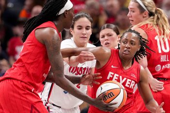 Indiana Fever forward Natasha Howard (6) hands off the ball to guard Kelsey Mitchell (0) during the first half of a game against the Washington Mystics on Friday, Aug. 15, 2025, at Gainbridge Fieldhouse in Indianapolis.