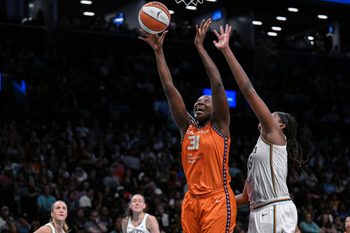 Aug 25, 2025; Brooklyn, New York, USA; Connecticut Sun center Tina Charles (31) shoots the ball while defended by New York Liberty center Jonquel Jones (35) during the second half at Barclays Center. Mandatory Credit: John Jones-Imagn Images