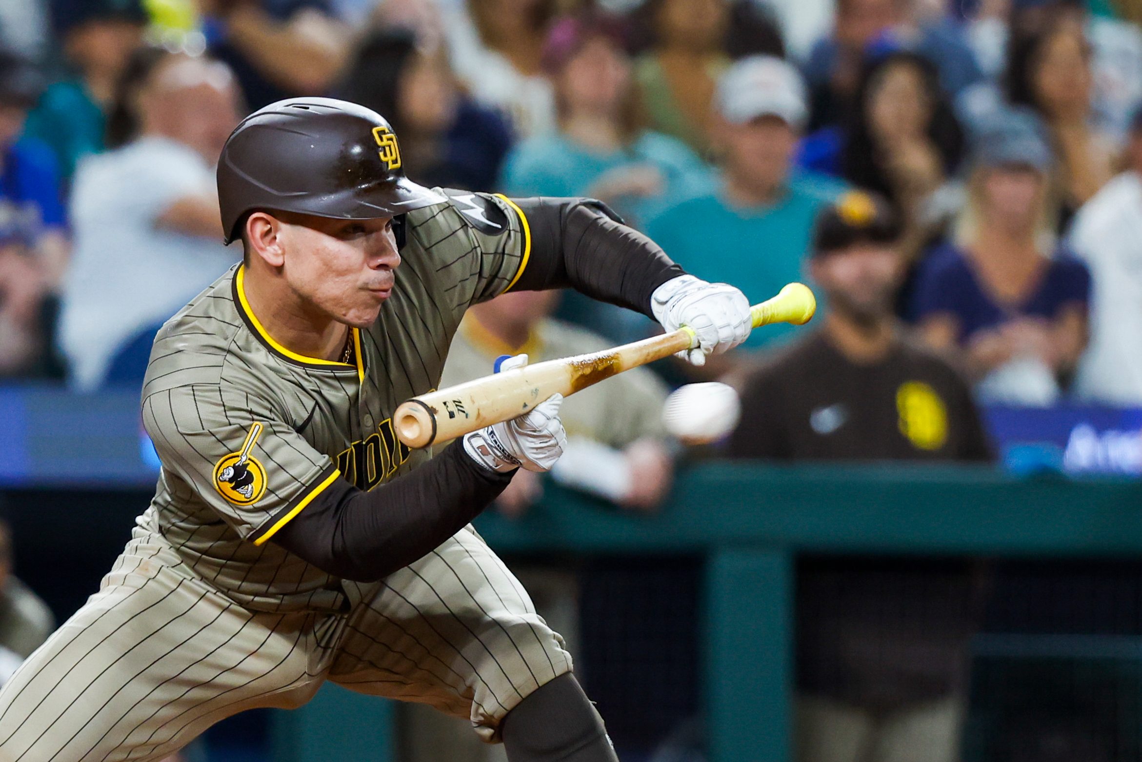 Aug 26, 2025; Seattle, Washington, USA; San Diego Padres catcher Freddy Fermin (54) hits an RBI-sacrifice bunt against the Seattle Mariners during the sixth inning at T-Mobile Park. Mandatory Credit: Joe Nicholson-Imagn Images