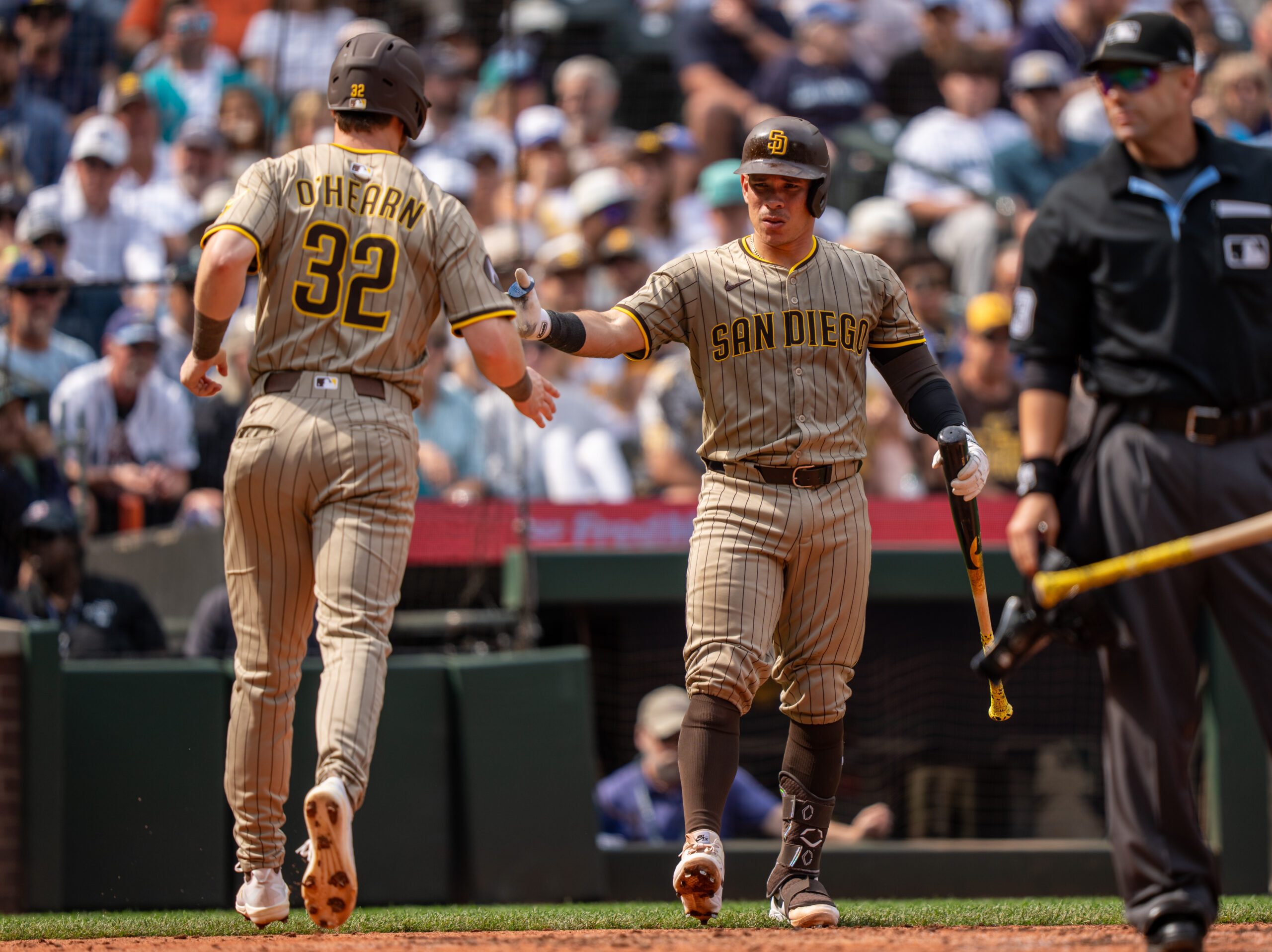 Aug 27, 2025; Seattle, Washington, USA; San Diego Padres designated hitter Ryan O'Hearn (32) is congratulated by catcher Freddy Fermin (54) during the sixth inning at T-Mobile Park. Mandatory Credit: Stephen Brashear-Imagn Images