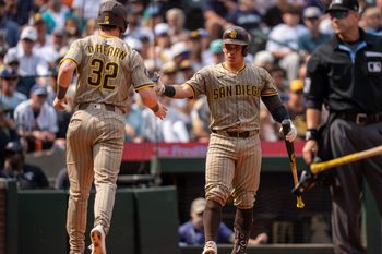 Aug 27, 2025; Seattle, Washington, USA; San Diego Padres designated hitter Ryan O'Hearn (32) is congratulated by catcher Freddy Fermin (54) during the sixth inning at T-Mobile Park. Mandatory Credit: Stephen Brashear-Imagn Images