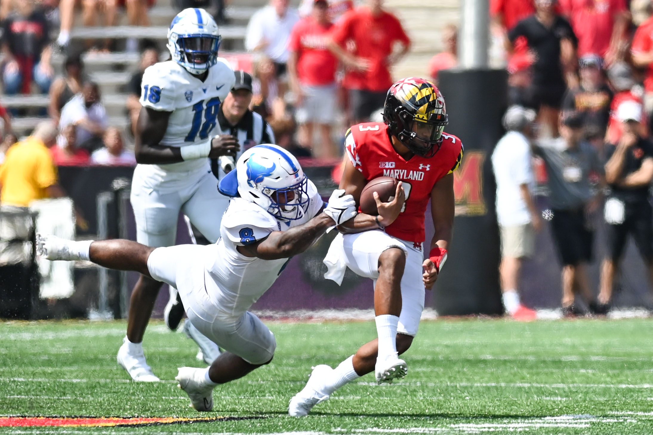 Sep 3, 2022; College Park, Maryland, USA;  Buffalo Bulls wide receiver Jovany Ruiz-Navarro (8) tackles Maryland Terrapins quarterback Taulia Tagovailoa (3) during the first half at Capital One Field at Maryland Stadium. Mandatory Credit: Tommy Gilligan-Imagn Images