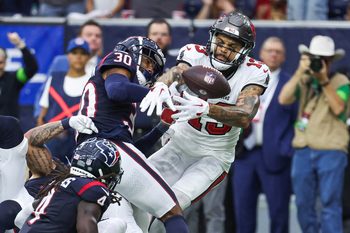 Nov 5, 2023; Houston, Texas, USA; Houston Texans safety DeAndre Houston-Carson (30) and Tampa Bay Buccaneers wide receiver Mike Evans (13) attempt to recover a fumble during the fourth quarter at NRG Stadium. Mandatory Credit: Troy Taormina-Imagn Images