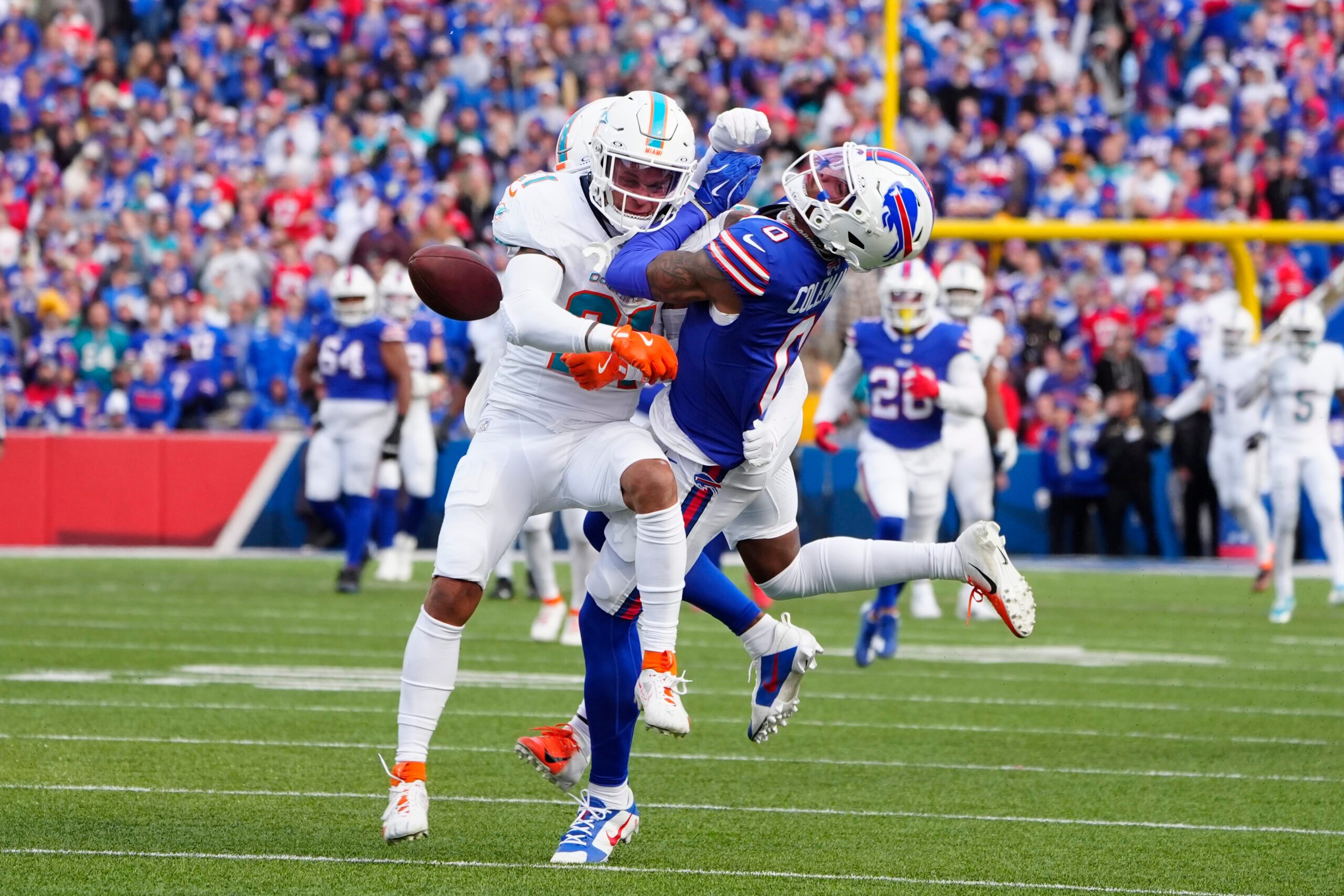Nov 3, 2024; Orchard Park, New York, USA; Miami Dolphins safety Jordan Poyer (21) separates Buffalo Bills wide receiver Keon Coleman (0) from the ball to break up a pass during the second half at Highmark Stadium. Mandatory Credit: Gregory Fisher-Imagn Images
