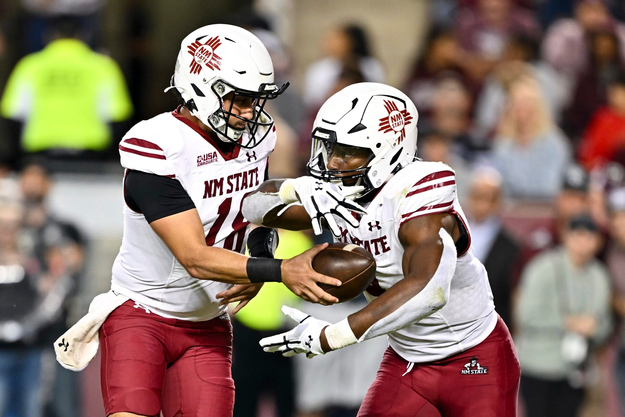 Nov 16, 2024; College Station, Texas, USA; New Mexico State Aggies quarterback Santino Marucci (18) hands the ball off to running back Mike Washington (4) during the fourth quarter at Kyle Field. Mandatory Credit: Maria Lysaker-Imagn Images