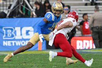 Nov 30, 2024; Pasadena, California, USA; UCLA Bruins defensive back Ramon Henderson (11) moves in to tackle Fresno State Bulldogs wide receiver Mac Dalena (0) during the fourth quarter at Rose Bowl. Mandatory Credit: Robert Hanashiro-Imagn Images