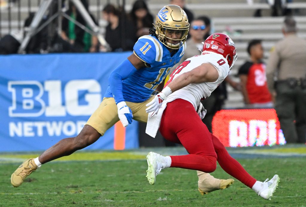 Nov 30, 2024; Pasadena, California, USA; UCLA Bruins defensive back Ramon Henderson (11) moves in to tackle Fresno State Bulldogs wide receiver Mac Dalena (0) during the fourth quarter at Rose Bowl. Mandatory Credit: Robert Hanashiro-Imagn Images