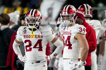 Indiana Hoosiers defensive back Bryson Bonds (24) and Indiana Hoosiers linebacker Jeff Utzinger (34) watch the second half of a game between the Indiana Hoosiers and the Notre Dame Fighting Irish in first round of the College Football Playoff on Saturday, Dec. 21, 2024, in South Bend. Notre Dame defeated Indiana 27-17.