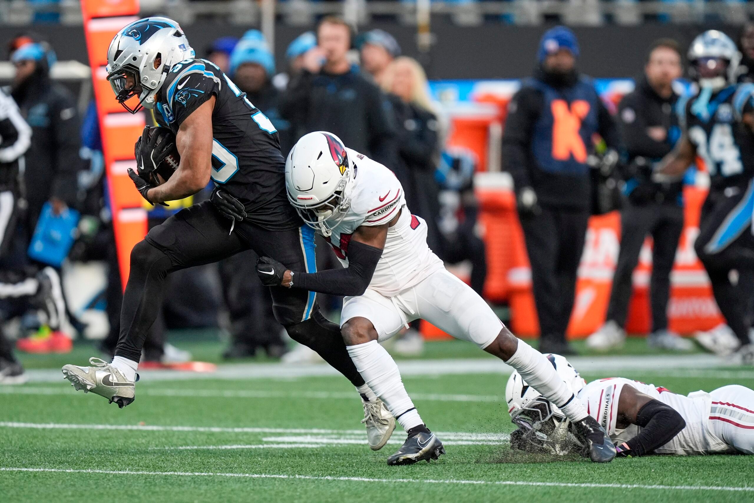 Dec 22, 2024; Charlotte, North Carolina, USA; Carolina Panthers running back Chuba Hubbard (30) tries to evade Arizona Cardinals safety Jalen Thompson (34) during the second half at Bank of America Stadium. Mandatory Credit: Jim Dedmon-Imagn Images