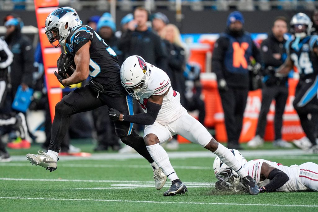 Dec 22, 2024; Charlotte, North Carolina, USA; Carolina Panthers running back Chuba Hubbard (30) tries to evade Arizona Cardinals safety Jalen Thompson (34) during the second half at Bank of America Stadium. Mandatory Credit: Jim Dedmon-Imagn Images