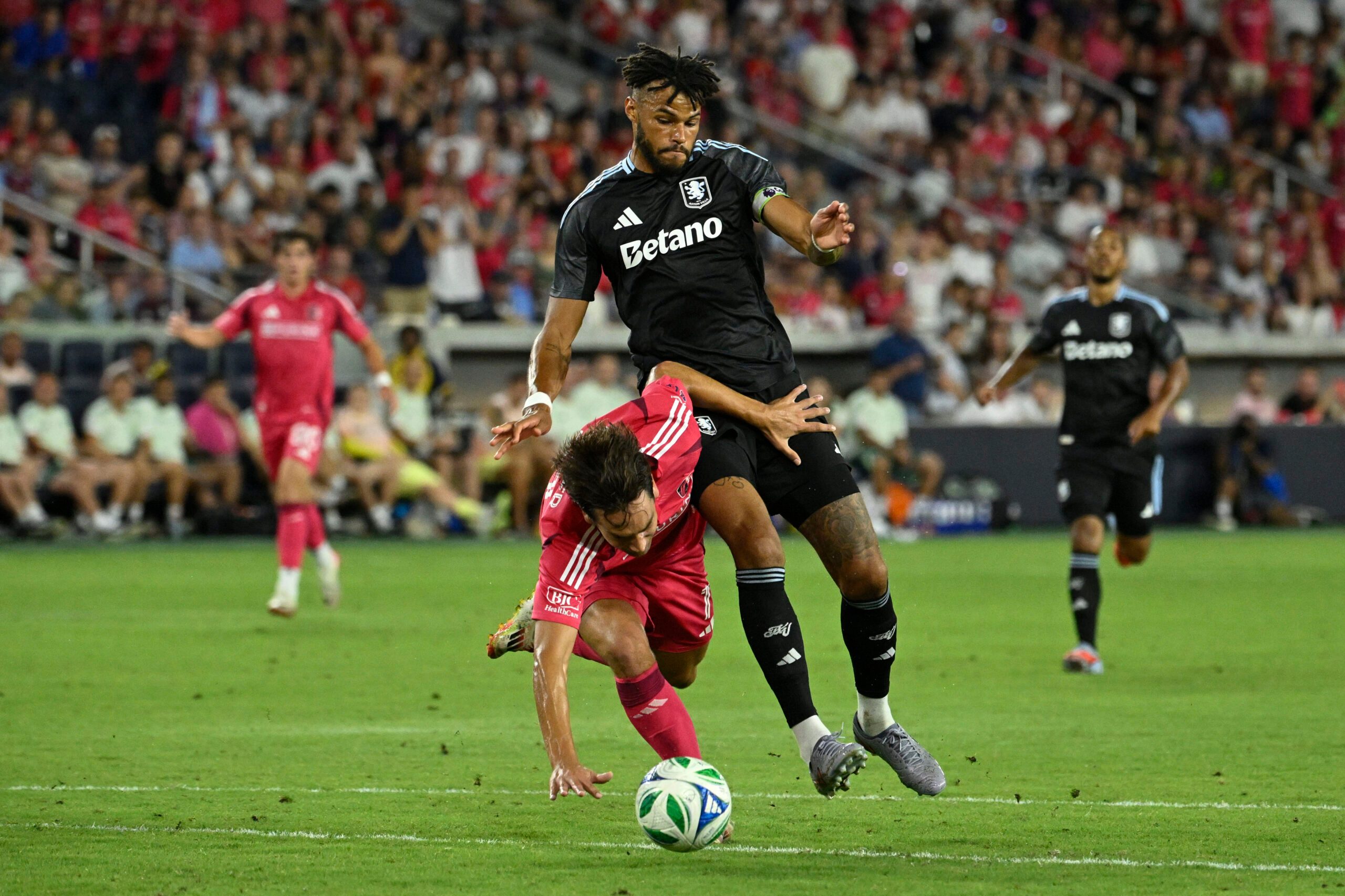 Jul 30, 2025; St. Louis, Missouri, USA; St. Louis City forward Simon Becher (11) falls to the pitch while battling Aston Villa defender Tyrone Mings (5) for the ball in the second half at Energizer Park. Mandatory Credit: Joe Puetz-Imagn Images