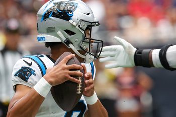Aug 16, 2025; Houston, Texas, USA; Carolina Panthers quarterback Bryce Young (9) tries to avoid the grip of Houston Texans defensive end Will Anderson Jr. (51) in the first quarter at NRG Stadium. Mandatory Credit: Thomas Shea-Imagn Images