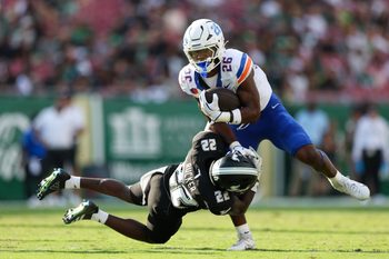 Aug 28, 2025; Tampa, Florida, USA; Boise State Broncos running back Sire Gaines (26) holds off South Florida Bulls cornerback De'Shawn Rucker (22) in the first quarter at Raymond James Stadium. Mandatory Credit: Nathan Ray Seebeck-Imagn Images