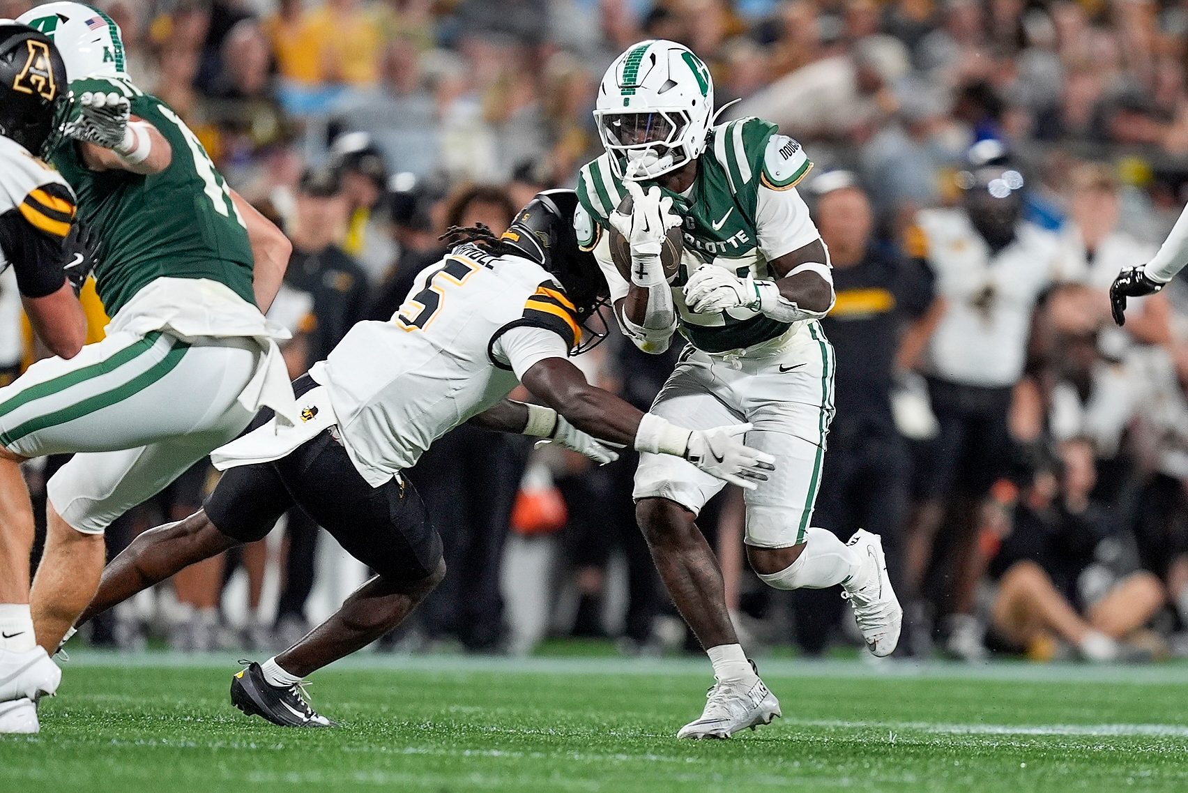 Aug 29, 2025; Charlotte, North Carolina, USA; Charlotte 49ers running back CJ Stokes (23) is tackled by Appalachian State Mountaineers defensive back Zyeir Gamble (5) during the second half at Bank of America Stadium. Mandatory Credit: Jim Dedmon-Imagn Images