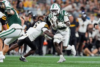 Aug 29, 2025; Charlotte, North Carolina, USA; Charlotte 49ers running back CJ Stokes (23) is tackled by Appalachian State Mountaineers defensive back Zyeir Gamble (5) during the second half at Bank of America Stadium. Mandatory Credit: Jim Dedmon-Imagn Images