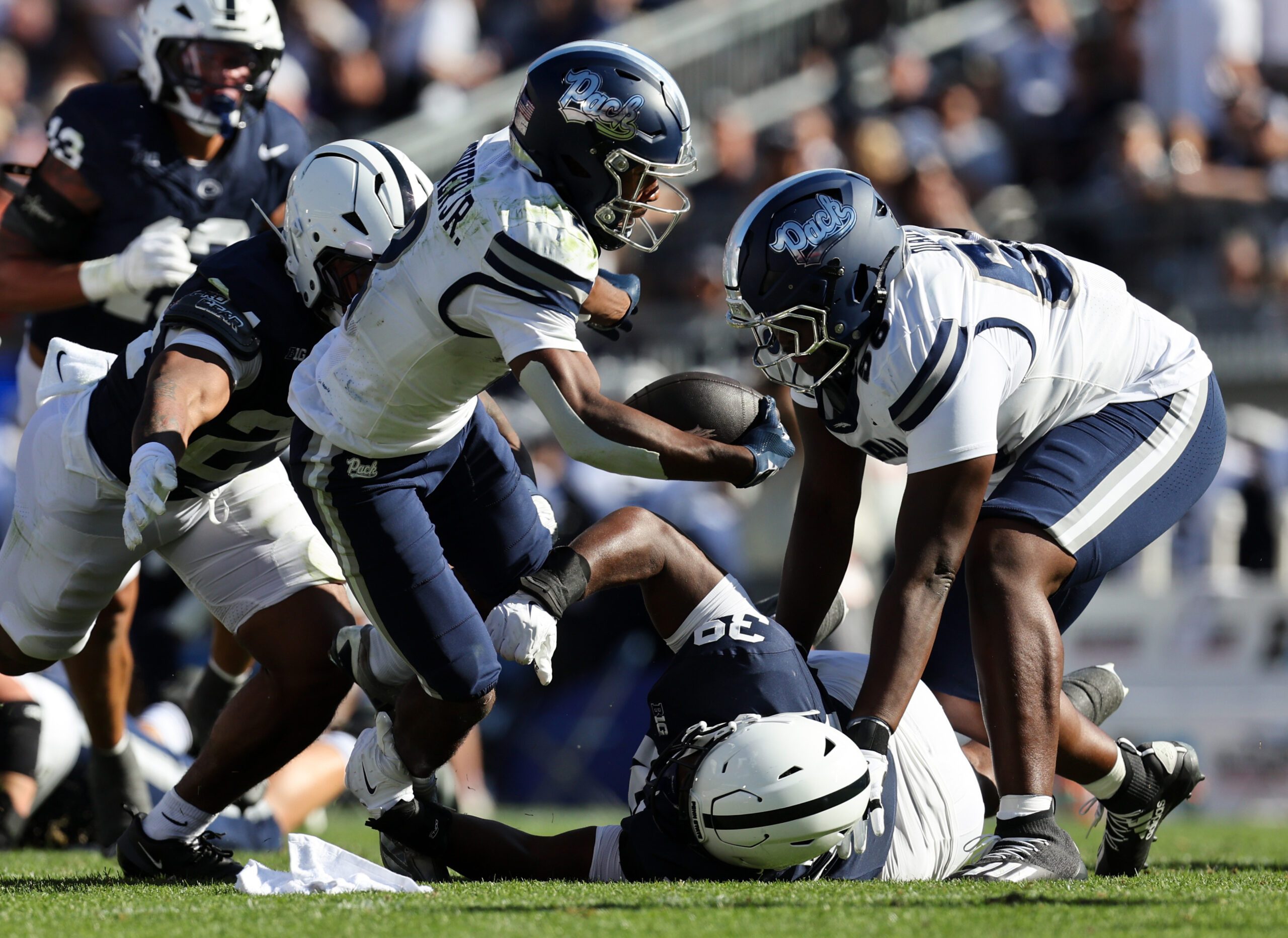Aug 30, 2025; University Park, Pennsylvania, USA; Nevada Wolf Pack running back Herschel Turner (2) runs with the ball while avoiding a tackle by Penn State Nittany Lions defensive tackle Ty Blanding (39) during the second quarter at Beaver Stadium. Mandatory Credit: Matthew O'Haren-Imagn Images