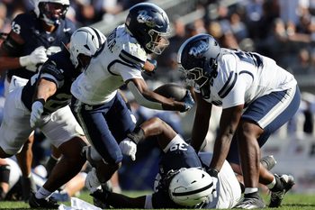 Aug 30, 2025; University Park, Pennsylvania, USA; Nevada Wolf Pack running back Herschel Turner (2) runs with the ball while avoiding a tackle by Penn State Nittany Lions defensive tackle Ty Blanding (39) during the second quarter at Beaver Stadium. Mandatory Credit: Matthew O'Haren-Imagn Images