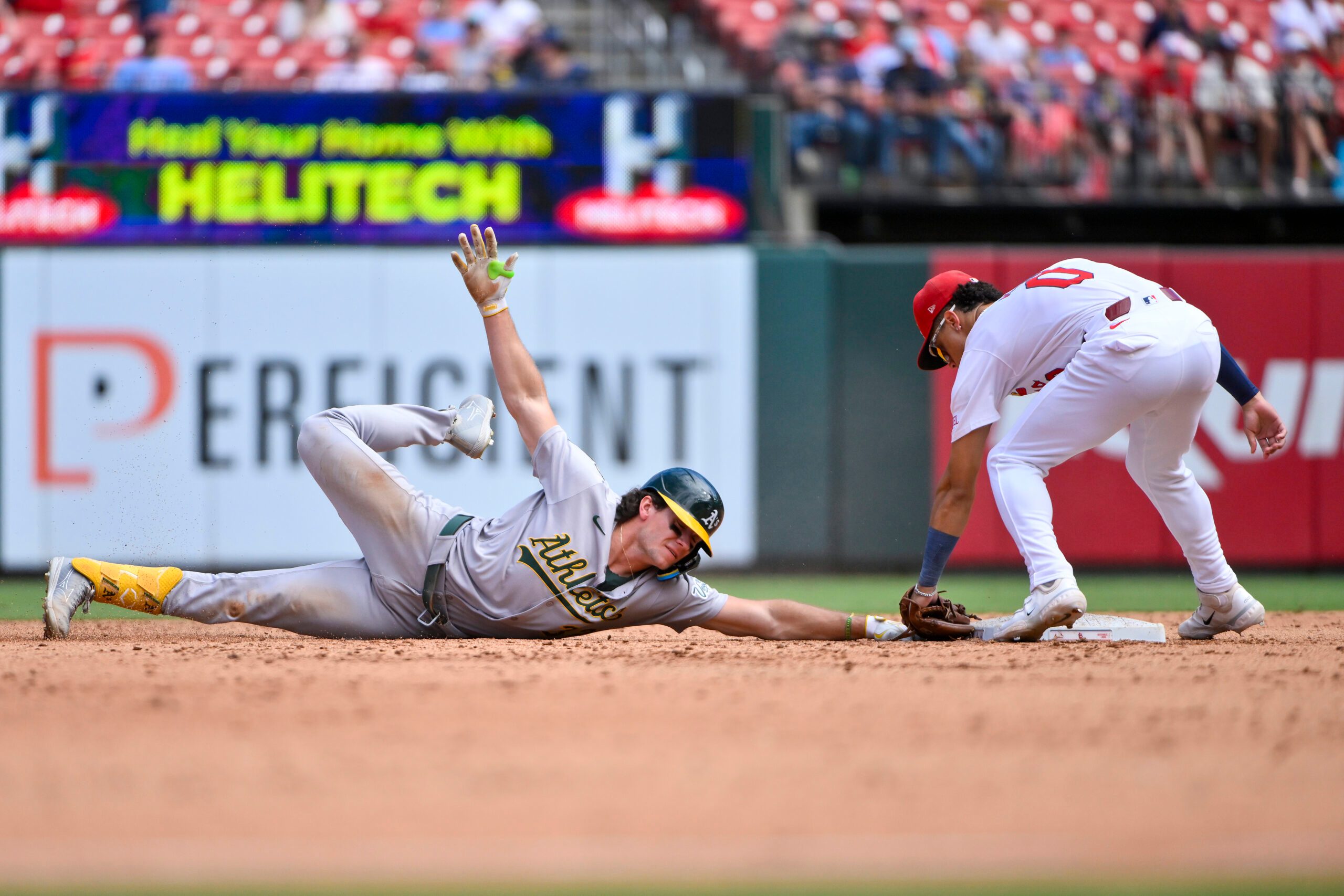 Sep 1, 2025; St. Louis, Missouri, USA;  Athletics left fielder Colby Thomas (32) is tagged out by St. Louis Cardinals shortstop Masyn Winn (0) during the sixth inning at Busch Stadium. Mandatory Credit: Jeff Curry-Imagn Images