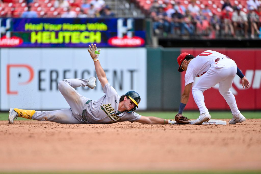 Sep 1, 2025; St. Louis, Missouri, USA; Athletics left fielder Colby Thomas (32) is tagged out by St. Louis Cardinals shortstop Masyn Winn (0) during the sixth inning at Busch Stadium. Mandatory Credit: Jeff Curry-Imagn Images