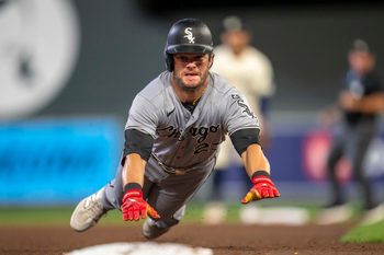 Sep 2, 2025; Minneapolis, Minnesota, USA; Chicago White Sox left fielder Andrew Benintendi (23) slides into third base safely after a fly ball against the Minnesota Twins in the sixth inning at Target Field. Mandatory Credit: Jesse Johnson-Imagn Images