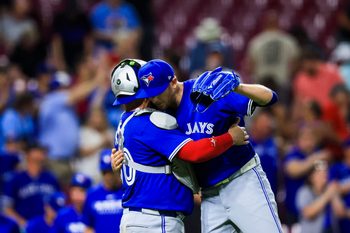 Sep 2, 2025; Cincinnati, Ohio, USA; Toronto Blue Jays catcher Alejandro Kirk (30) hugs relief pitcher Jeff Hoffman (23) after the victory over the Cincinnati Reds at Great American Ball Park. Mandatory Credit: Katie Stratman-Imagn Images