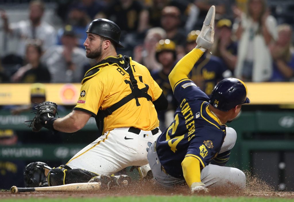 Sep 5, 2025; Pittsburgh, Pennsylvania, USA; Milwaukee Brewers catcher William Contreras (24) slides behind Pittsburgh Pirates catcher Joey Bart (14) to score a run during the ninth inning at PNC Park. Mandatory Credit: Charles LeClaire-Imagn Images