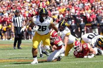 Sep 6, 2025; Ames, Iowa, USA; Iowa Hawkeyes running back Xavier Williams (26) runs with the ball against Iowa State Cyclones linebacker Kooper Ebel (47) during the second quarter at Jack Trice Stadium. Mandatory Credit: Reese Strickland-Imagn Images