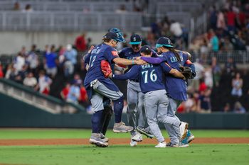 Sep 6, 2025; Cumberland, Georgia, USA; Seattle Mariners catcher Cal Raleigh (29), first base Josh Naylor (12), second base Leo Rivas (76), and shortstop J.P. Crawford (3) celebrate a victory against the Atlanta Braves after the game at Truist Park. Mandatory Credit: Jordan Godfree-Imagn Images