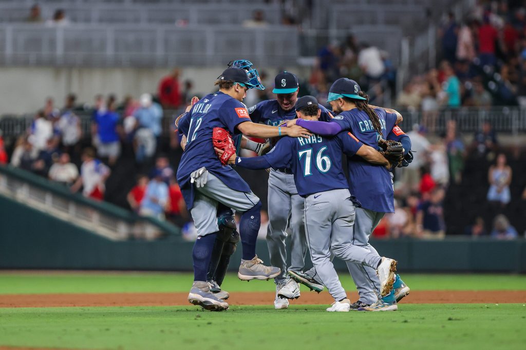 Sep 6, 2025; Cumberland, Georgia, USA; Seattle Mariners catcher Cal Raleigh (29), first base Josh Naylor (12), second base Leo Rivas (76), and shortstop J.P. Crawford (3) celebrate a victory against the Atlanta Braves after the game at Truist Park. Mandatory Credit: Jordan Godfree-Imagn Images