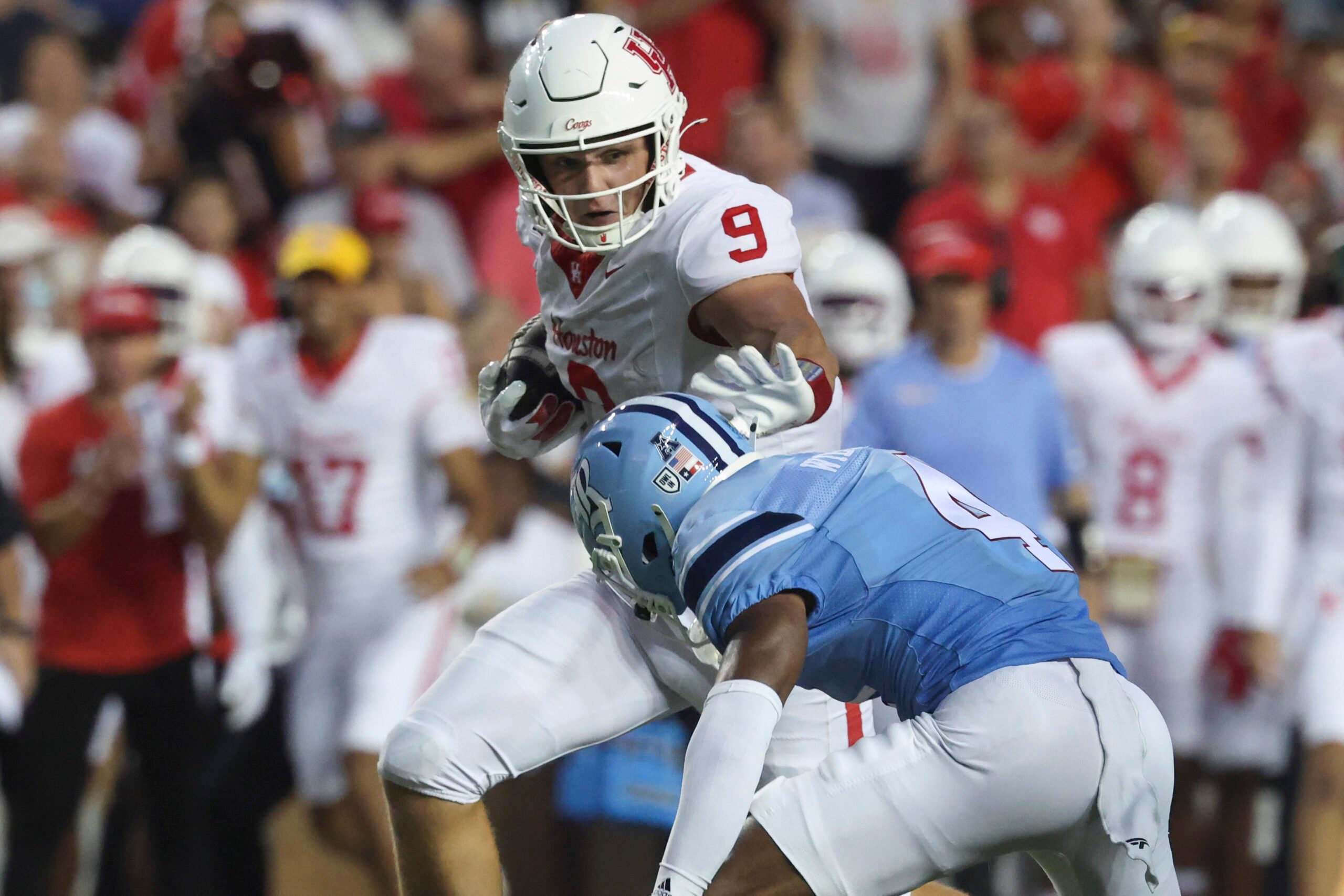 Sep 6, 2025; Houston, Texas, USA; Houston Cougars tight end Tanner Koziol (9) runs with the ball as Rice Owls safety Marcus Williams (4) attempts to make a tackle during the third quarter at Rice Stadium. Mandatory Credit: Troy Taormina-Imagn Images