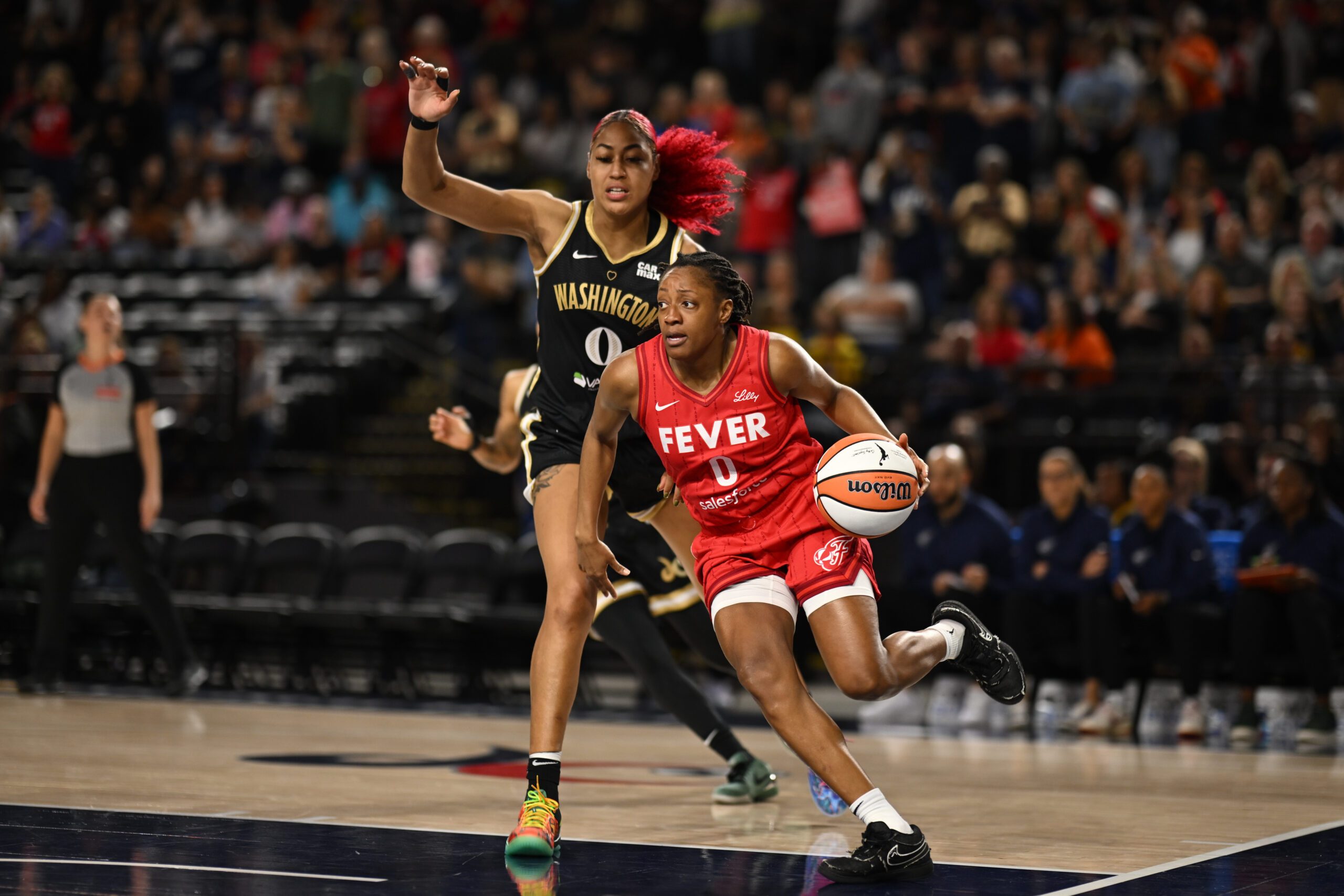 Sep 7, 2025; Baltimore, MD, USA; Indiana Fever guard Kelsey Mitchell (0) drives to the basket in front of Washington Mystics forward Shakira Austin (0) during the first quarter at CFG Bank Arena. Mandatory Credit: Rafael Suanes-Imagn Images