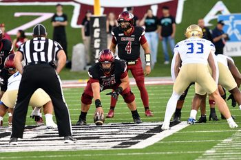 Aggie quarterback Logan Fife (4) looks over the defense as NMSU took on the University of Tulsa Golden Hurricane on Saturday in Las Cruces.