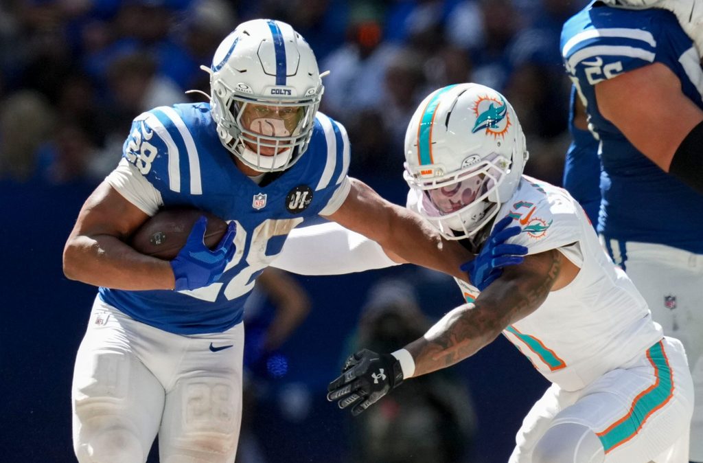 Sep 7, 2025; Indianapolis, Indiana, USA; Miami Dolphins safety Dante Trader Jr. (11) attempts to bring down Indianapolis Colts running back Jonathan Taylor (28) during the second half of a game at Lucas Oil Stadium. Mandatory Credit: Christine Tannous-USA TODAY Network via Imagn Images