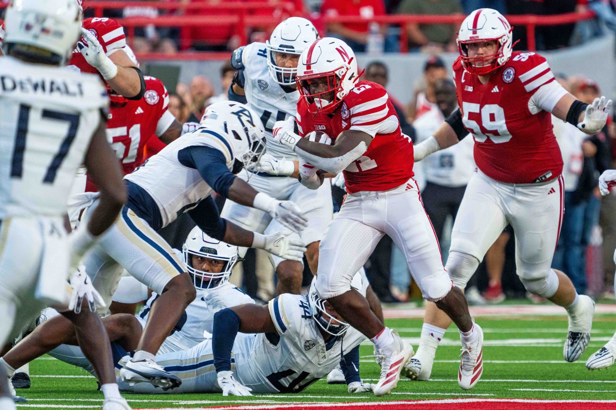 Sep 6, 2025; Lincoln, Nebraska, USA; Nebraska Cornhuskers running back Emmett Johnson (21) runs against Akron Zips defenders during the second quarter at Memorial Stadium. Mandatory Credit: Dylan Widger-Imagn Images