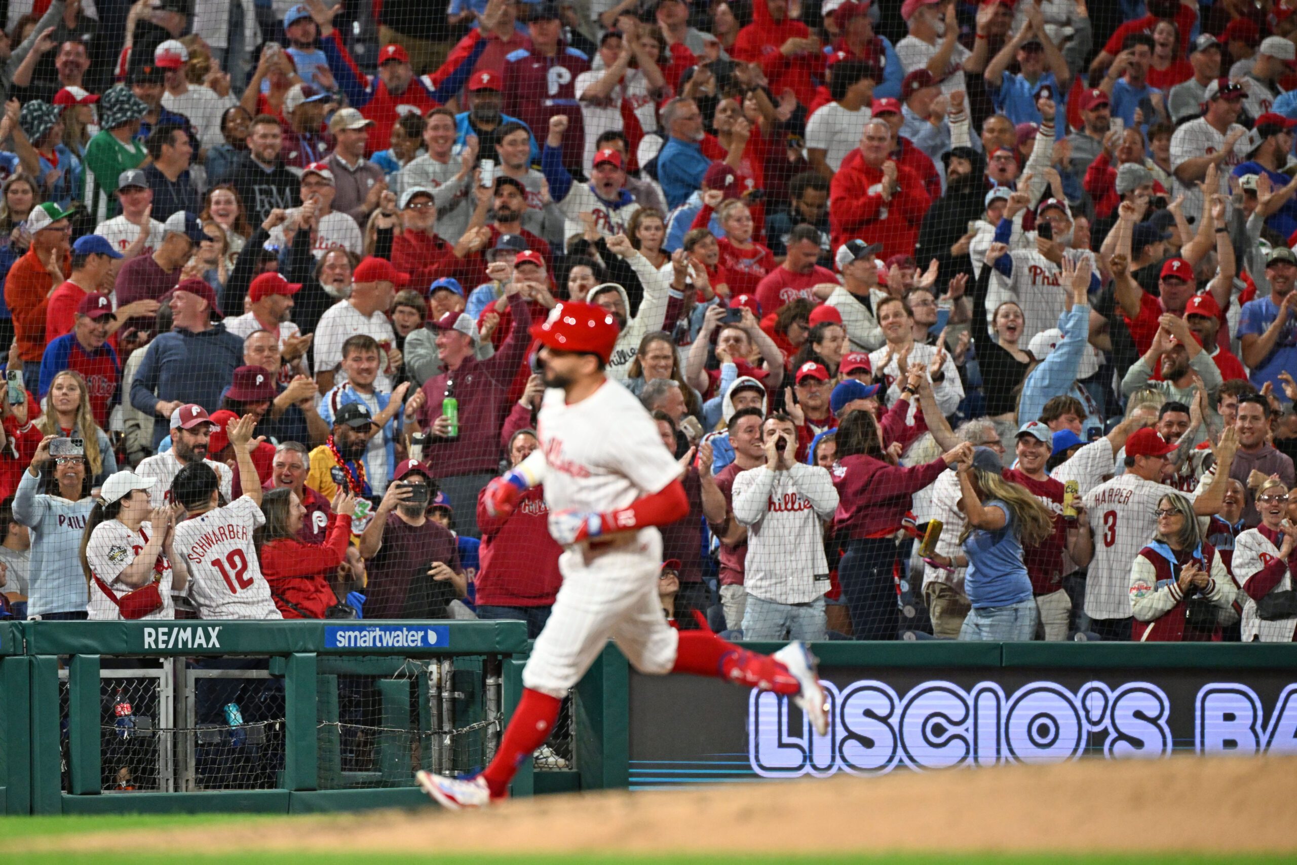 Sep 9, 2025; Philadelphia, Pennsylvania, USA; Fans react as Philadelphia Phillies outfielder Kyle Schwarber (12) runs the bases after hitting his 50th home run of the season during the seventh inning against the New York Mets at Citizens Bank Park. Mandatory Credit: Eric Hartline-Imagn Images