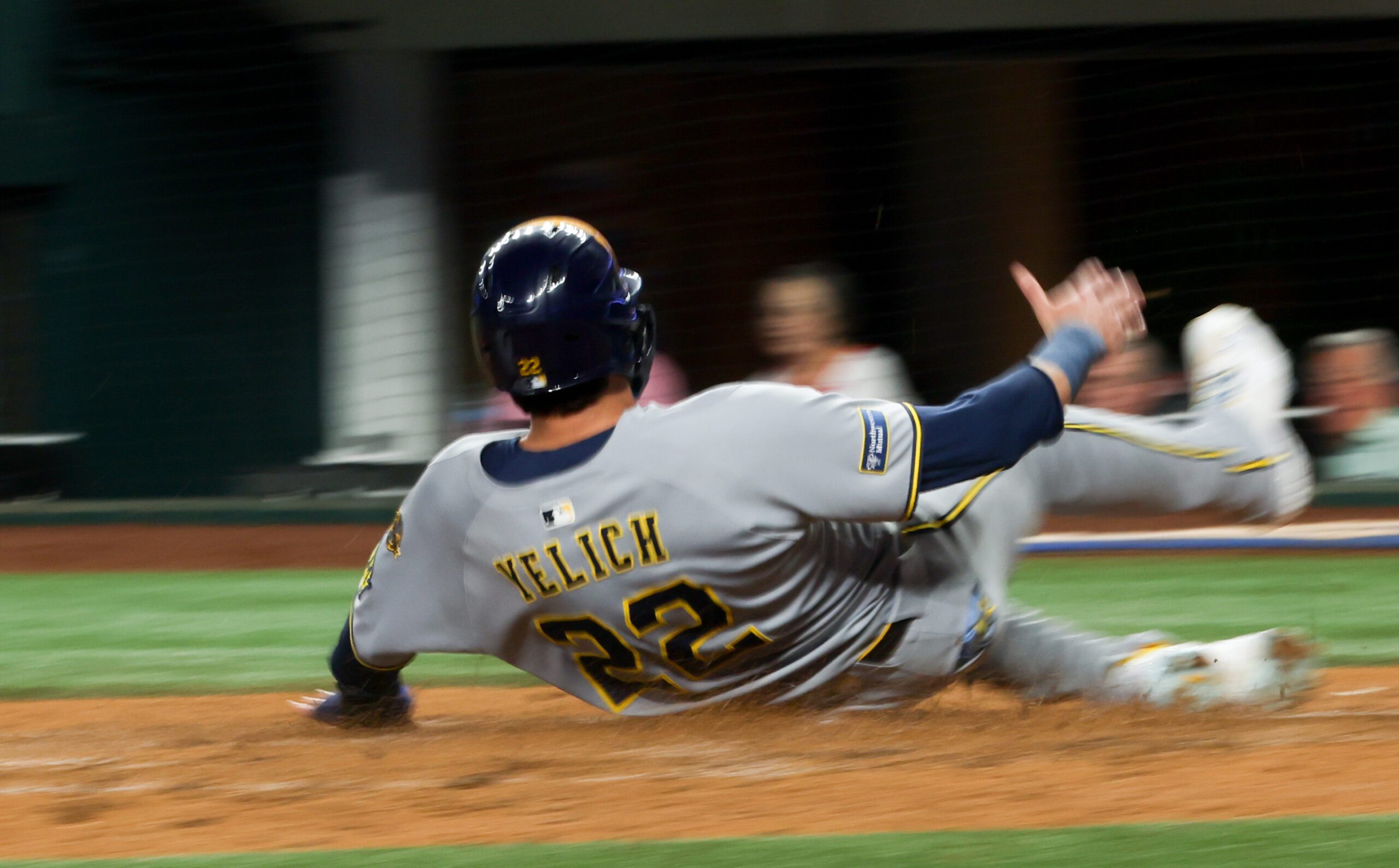 Sep 9, 2025; Arlington, Texas, USA;  (Editor's note: Slow shutter image.)  Milwaukee Brewers designated hitter Christian Yelich (22) scores during the fifth inning against the Texas Rangers at Globe Life Field. Mandatory Credit: Kevin Jairaj-Imagn Images